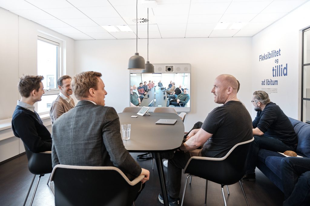 Mænd i hybridt møde ved hjælp af cisco collaboration og AI løsninger